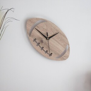 Horloge murale Ballon de Rugby unique en stratifié - Larg 17 cm - haut 30 cm - Mécanisme silencieux.