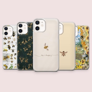 Könnte beinhalten: Eine Sammlung von fünf Handyhüllen mit Bienenmotiven. Die Hüllen zeigen verschiedene Muster, darunter Illustrationen von Bienen, ein dunkelgrünes Muster mit goldenen Bienen, eine cremefarbene Hülle mit einer Biene und dem Schriftzug "bee happy", eine beige Hülle mit einer Biene und ein Blumenmuster.