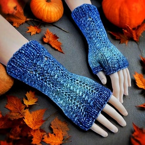 Puede incluir: Un par de guantes sin dedos de punto azul con un patrón texturizado. Los guantes están hechos con un hilo degradado que pasa de un azul más oscuro a un azul más claro.