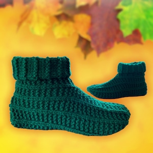Peut inclure: Une paire de chaussons en tricot vert avec un revers plié. Les chaussettes sont faites avec un point texturé et sont photographiées sur un fond flou de feuilles d'automne.