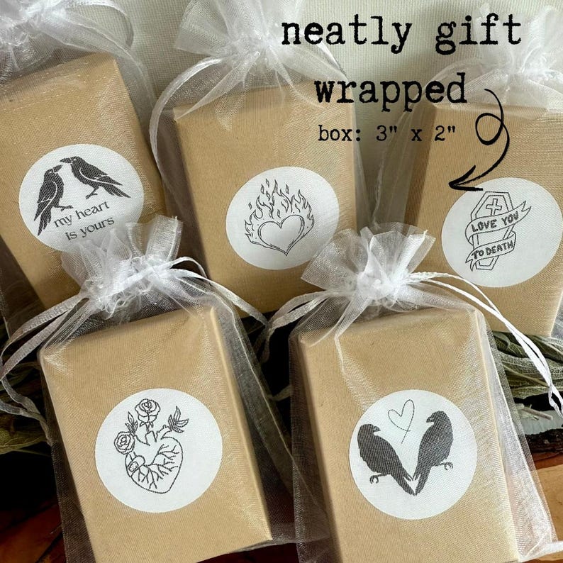 May include: Several small, gift-wrapped boxes in tan paper are tied with white tulle and ribbons. Each box has a white sticker with a black graphic and text. The text on the image reads "neatly gift wrapped" and "box: 3" x 2".