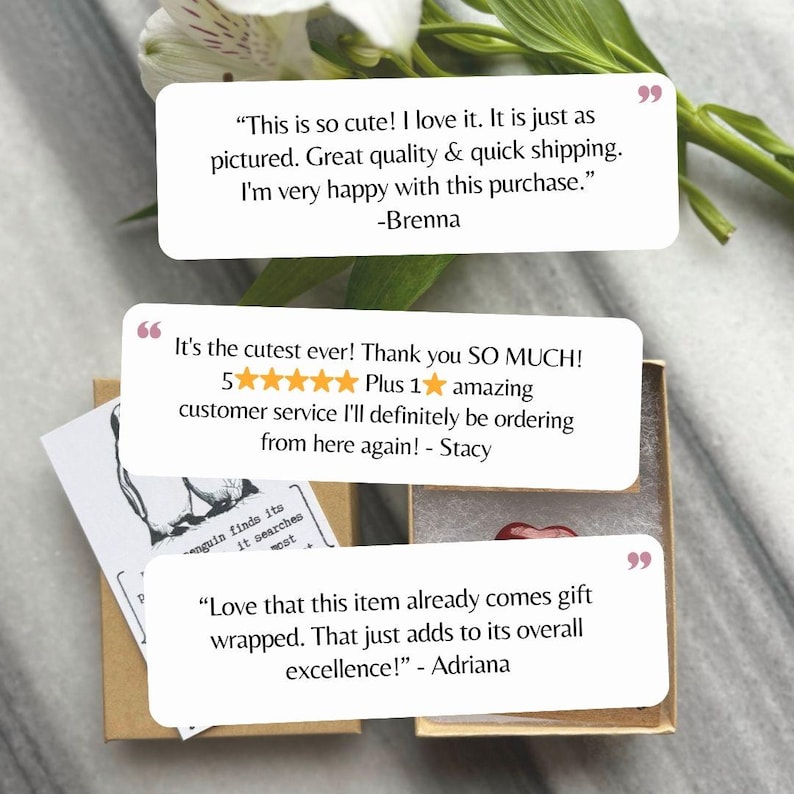 May include: A small, open gift box with a red heart-shaped object inside. The box is surrounded by white text bubbles with customer reviews. The reviews mention quality, quick shipping, and customer service.