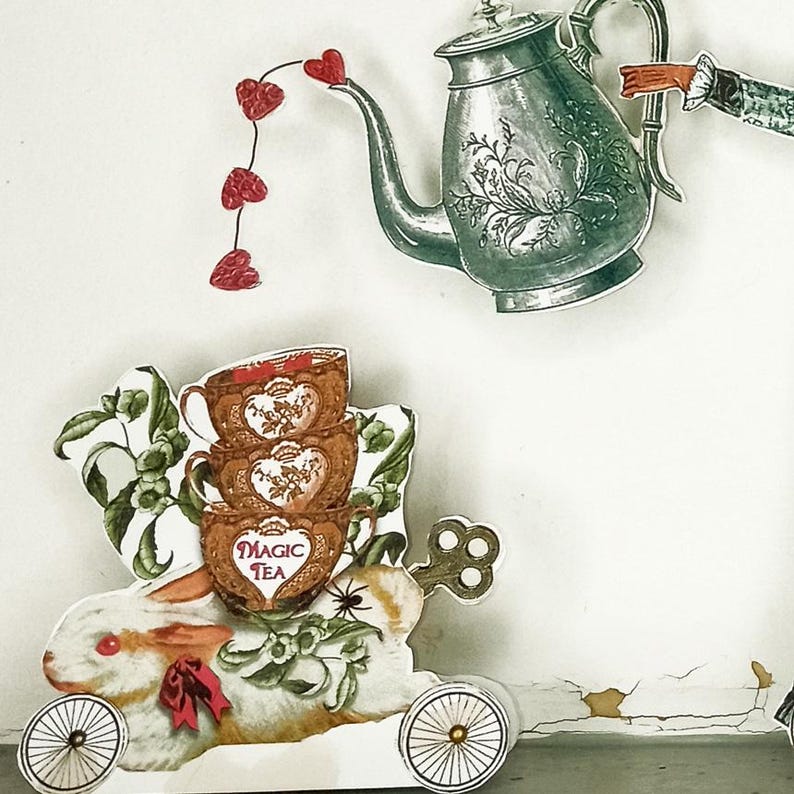 Peut inclure: Illustration fantaisiste avec une th&eacute;i&egrave;re versant des gouttes en forme de c&oelig;ur rouges sur une pile de tasses &agrave; th&eacute; avec l'inscription "Magic Tea". Un lapin blanc avec un n&oelig;ud rouge et une cl&eacute; sur roues compl&egrave;tent la sc&egrave;ne.