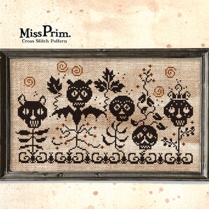 May include: Cross stitch pattern featuring a whimsical Halloween scene with black and white skulls, flowers, and vines. The pattern is framed in a black frame with a distressed wood finish. The text "Miss Prim. Cross Stitch Pattern" is visible at the top of the image.