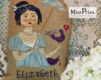 May include: A cross-stitch pattern depicting a woman in a blue dress with an umbrella and two purple birds. The name "Elizabeth" is stitched below the woman. The text "Miss Prim. Cross Stitch Pattern" is in the upper right corner.