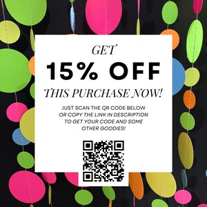 May include: A white square with black text that reads "GET 15% OFF THIS PURCHASE NOW!" and "JUST SCAN THE QR CODE BELOW OR COPY THE LINK IN DESCRIPTION TO GET YOUR CODE AND SOME OTHER GOODIES!" A black and white QR code is in the center of the square. The background is a black wall with a colorful garland of circles.
