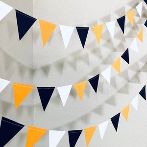 May include: A Halloween party banner with black, orange, and white triangle flags strung together.