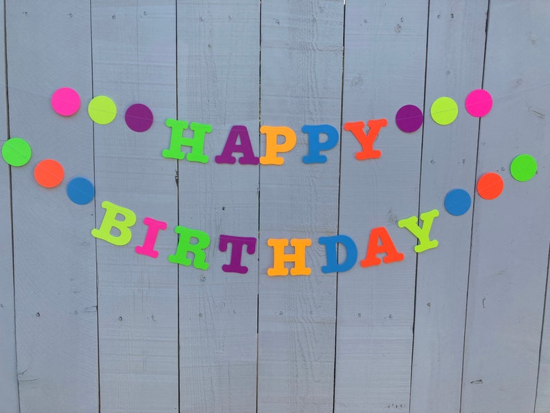 May include: A colorful banner with the words "Happy Birthday" in neon colors. The banner is decorated with circles in various colors, including green, orange, pink, purple, and blue.