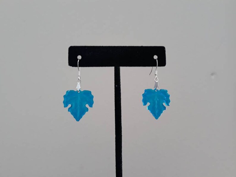 May include: A pair of silver dangle earrings with blue leaf-shaped charms.