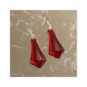 May include: A pair of red teardrop-shaped earrings with silver hooks.