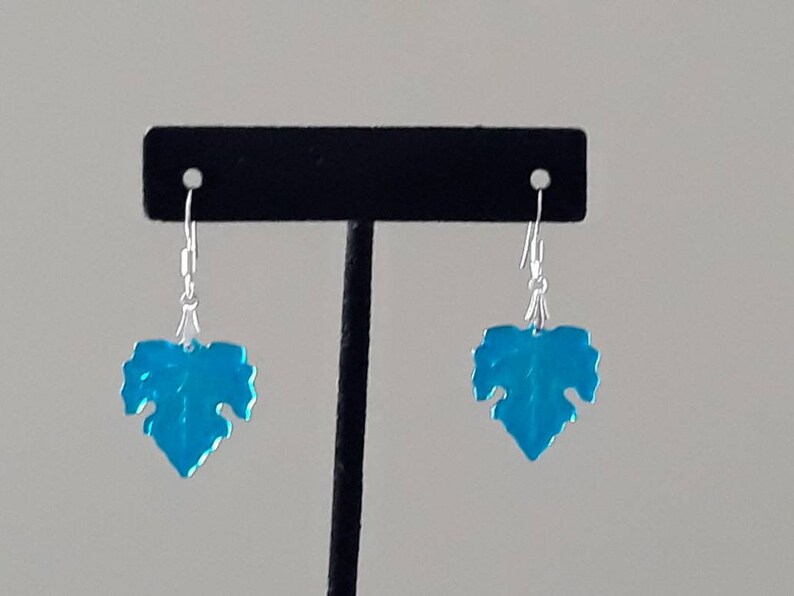 May include: A pair of silver dangle earrings with blue leaf-shaped charms.