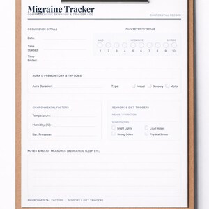 Puede incluir: Un portapapeles con un formulario impreso "Migraine Tracker". El formulario incluye secciones para detalles de ocurrencia, severidad del dolor, síntomas del aura, factores ambientales y notas. El portapapeles tiene un clip plateado.