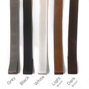 May include: Five different colored ribbon samples. The colors are grey, black, white, light brown, and dark brown.