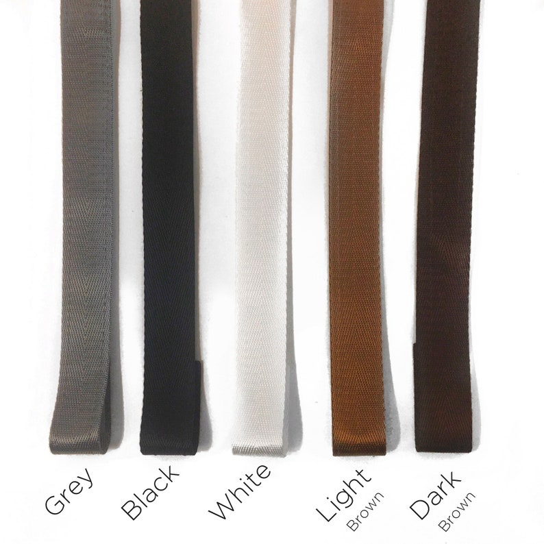 May include: Five different colored ribbon samples. The colors are grey, black, white, light brown, and dark brown.