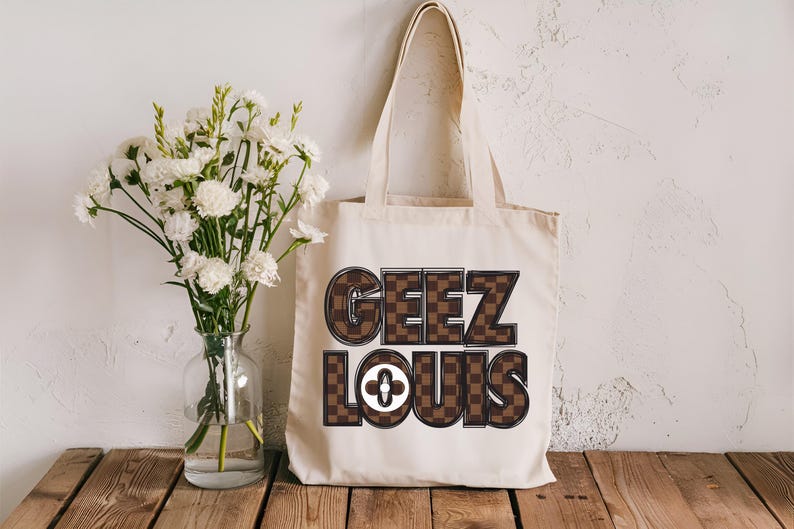 Pu&ograve; includere: Una borsa tote in tela bianca con testo stampato a scacchi marroni e neri che dice "Geez Louis".