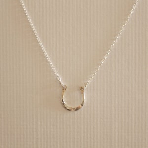 Peut inclure: Un collier avec un pendentif en forme de fer &agrave; cheval en argent sur une cha&icirc;ne en argent.