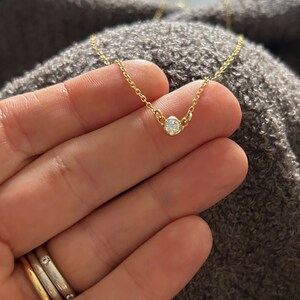 K&ouml;nnte beinhalten: Eine zarte goldene Kettenkette mit einem kleinen, runden, klaren Diamantenanh&auml;nger.