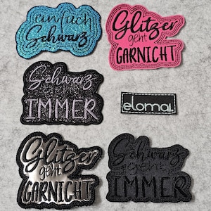 Könnte beinhalten: Eine Sammlung von gestickten Aufnähern mit Text in verschiedenen Farben. Die Aufnäher enthalten Sätze wie "einfach Schwarz", "Glitzer geht GARNICHT" und "Schwarz IMMER". Ein kleines rechteckiges Patch mit dem Text "eloma." ist ebenfalls vorhanden.