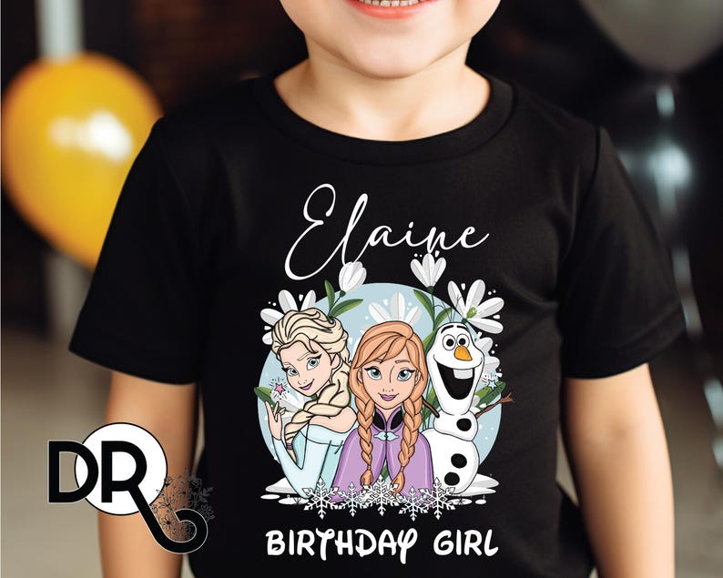 a young boy wearing a black shirt with a frozen princess picture on it