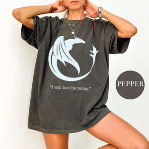 a woman wearing a t - shirt with a dragon on it
