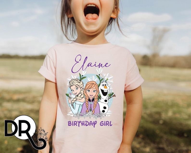 a little girl with her mouth open wearing a pink shirt