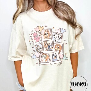 A woman wearing a white t-shirt with a collage of cartoon animal characters and stars on it.