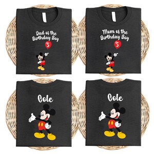 four black t-shirts with Mickey Mouse printed on them, each with a different name and age printed on the front.