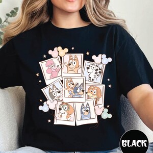 A woman wearing a black t-shirt with a collage of cartoon animal characters and various Disney-themed elements.