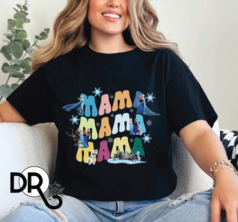 a woman sitting on a couch wearing a black mama mama shirt