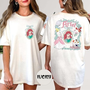 two women wearing white t-shirts with the Disney character Ariel from The Little Mermaid.