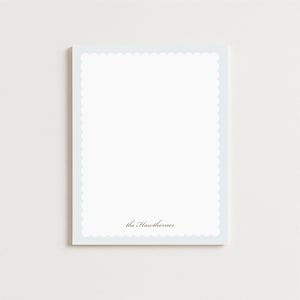 May include: A rectangular white notepad featuring a scalloped edge border and the text the Hawthornes printed in a dark gray script font at the bottom center of the page. The stationery has a clean, simple design with ample space.