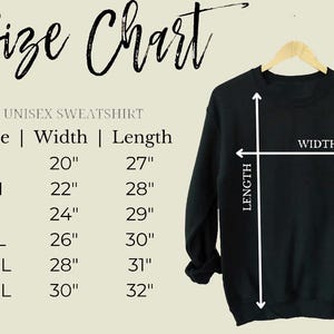 K&ouml;nnte beinhalten: Ein schwarzes Unisex-Sweatshirt auf einem Holzb&uuml;gel. Das Bild zeigt eine Gr&ouml;&szlig;entabelle mit Breiten- und L&auml;ngenma&szlig;en in Zoll, von Gr&ouml;&szlig;e S bis 3XL. Der Text "Size Chart" befindet sich oben.