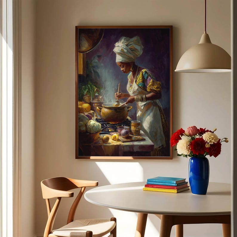 May include: A framed painting depicts a person in a kitchen, stirring a pot on a stove. The person wears a white head wrap and apron. A blue vase with red and white flowers sits on a white table. A wooden chair and a hanging light are also visible.
