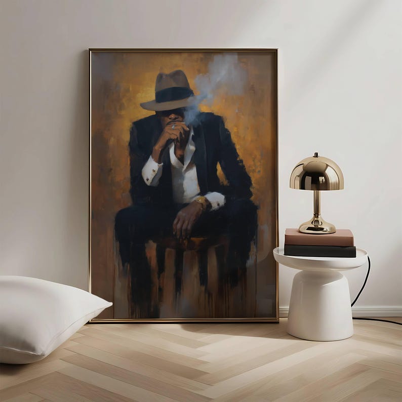 Puede incluir: Una pintura enmarcada representa a una persona con un traje negro y sombrero fedora, fumando un cigarrillo. La obra de arte tiene un fondo c&aacute;lido y dorado y se exhibe en una habitaci&oacute;n con una mesita auxiliar blanca y una l&aacute;mpara dorada.
