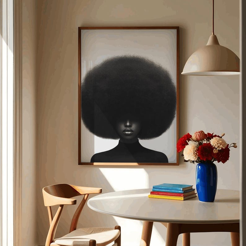 May include: A framed art print featuring a black and white portrait of a person with a large afro. The person is wearing a black turtleneck. The artwork is displayed in a room with a wooden chair, a table, and a blue vase with flowers.