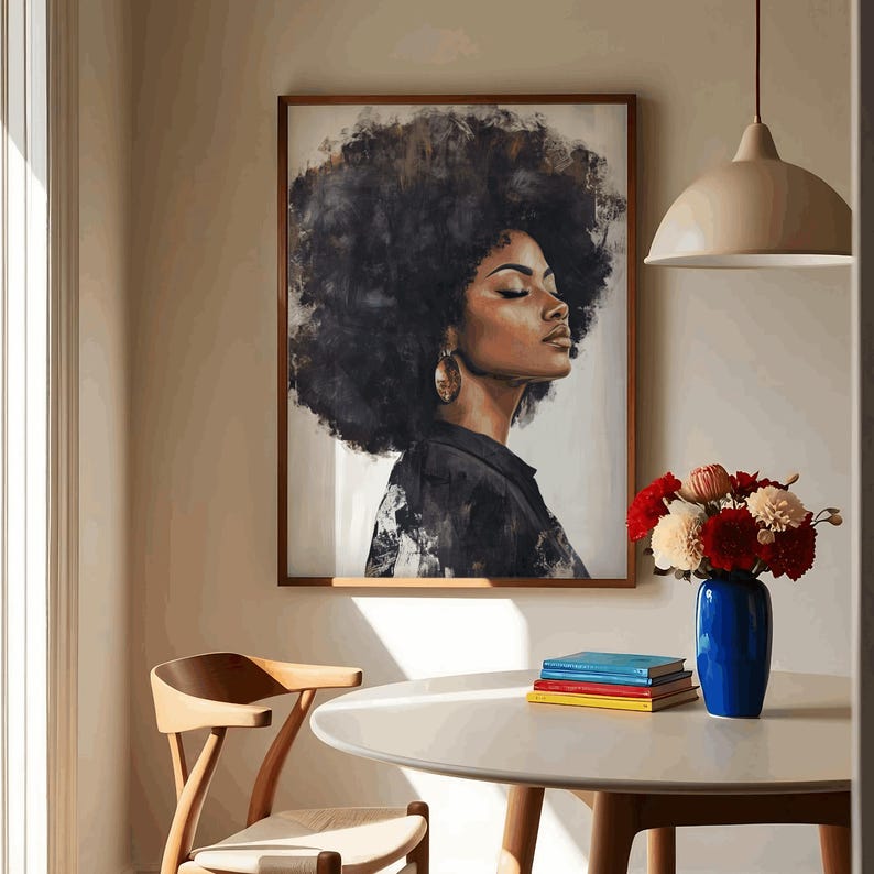 May include: A framed painting of a woman with dark brown curly hair, wearing a black shirt and large gold earrings. The painting is hanging on a beige wall above a white table with a stack of books and a vase of flowers.
