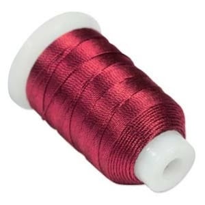 May include: A spool of maroon embroidery thread wound on a white plastic bobbin.