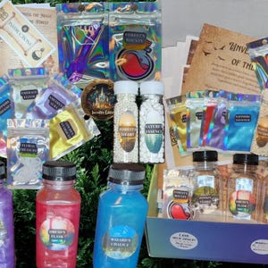 May include: A collection of potion-making supplies, including colorful glass bottles, small bags of iridescent glitter, and white pearl sprinkles. The bottles are labeled with names like "Wizard's Chalice", "Druid's Flask", and "Potion Vessel". The set also includes a small bag of white pearl sprinkles labeled "Nature's Essence" and a small bag of white pearl sprinkles labeled "Forest's Heart".