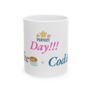 May include: White ceramic mug with the words "Perfect Day!!!" in pink and blue, along with a coffee cup graphic and the word "Coding". The mug has a glossy finish and a standard handle.