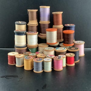 Vintage thread spools of various brand names, sizes and colors