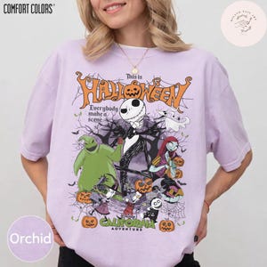 May include: Orchid-colored t-shirt with a graphic featuring characters from The Nightmare Before Christmas. The design includes Jack Skellington, Sally, and Oogie Boogie, with the text "This is Halloween" and "California Adventure."