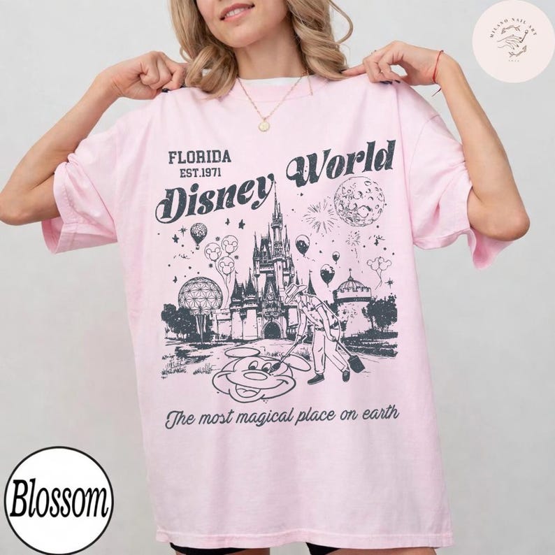 Może przedstawiać: Jasnor&oacute;żowa koszulka z grafiką zamku Disney World, Myszki Miki i napisem "Florida Disney World Est. 1971". Koszulka ma r&oacute;wnież napis "The most magical place on earth".