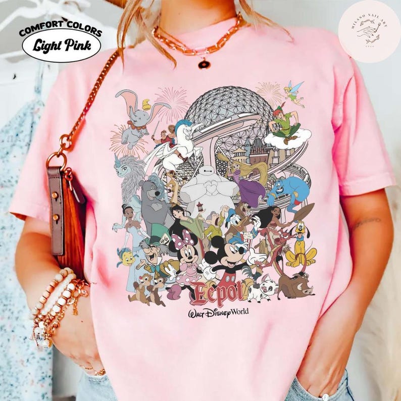 Puede incluir: Camiseta rosa claro Comfort Colors con un gr&aacute;fico colorido de personajes de Disney y el logotipo de Epcot. El dise&ntilde;o incluye a Mickey Mouse, Minnie Mouse y otros personajes. La camiseta tiene la inscripci&oacute;n "Light Pink".