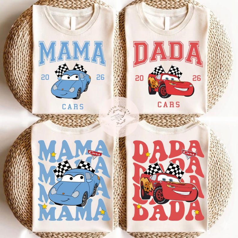 May include: Four cream-colored t-shirts with car-themed designs. Two shirts say "MAMA" in blue with a blue car graphic, and two say "DADA" in red with a red car graphic. Each shirt has the word "CARS" and the numbers "20" and "26".
