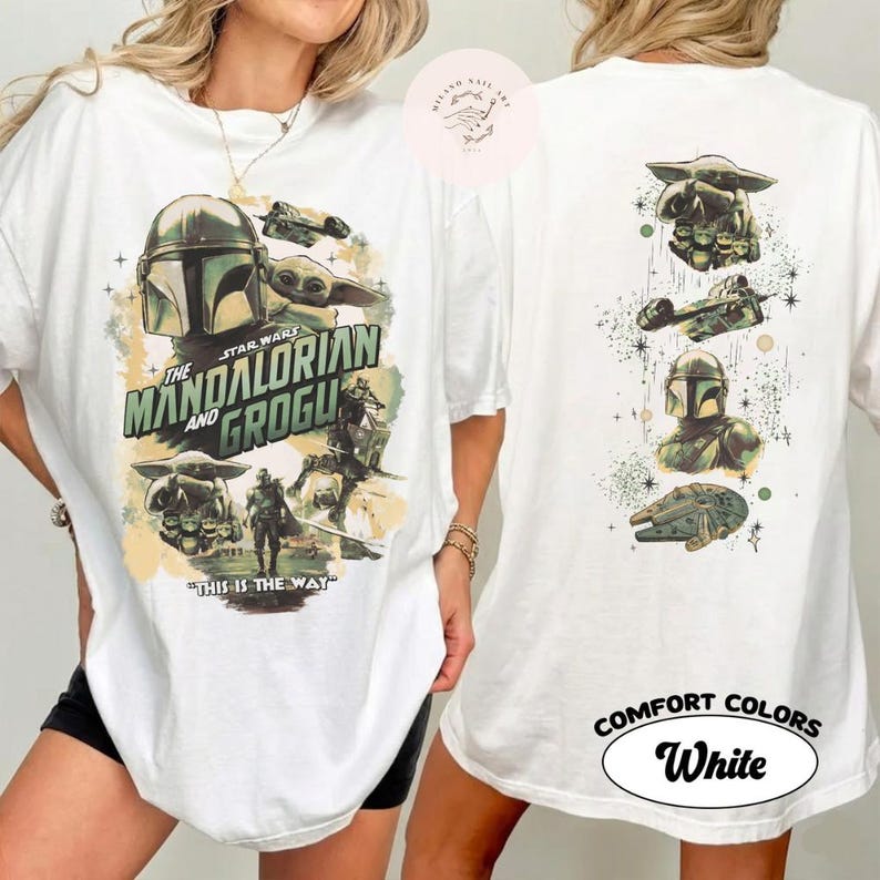 May include: White t-shirt with a Star Wars design featuring The Mandalorian and Grogu. The front displays the text "The Mandalorian and Grogu" and "This is the Way." The back of the shirt has additional Star Wars graphics.