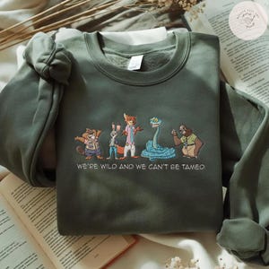 May include: A set of three ceramic nesting bowls in graduating sizes. The bowls feature a speckled, cream-colored exterior and a smooth, light blue interior. The largest bowl measures approximately 8 inches in diameter.