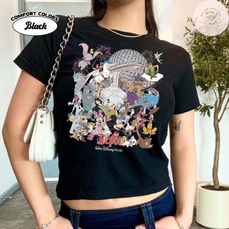Puede incluir: Camiseta negra con un gr&aacute;fico colorido de personajes de Disney y el logotipo de Epcot. El dise&ntilde;o incluye a Mickey Mouse, Dumbo y Peter Pan. El texto "Comfort Colors" y "Black" est&aacute; en un &oacute;valo blanco en la parte superior izquierda.