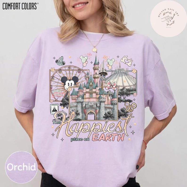 May include: Orchid-colored t-shirt with a graphic of a Disney castle, a Ferris wheel, and the text "The Happiest Place on Earth." The shirt is from Comfort Colors.
