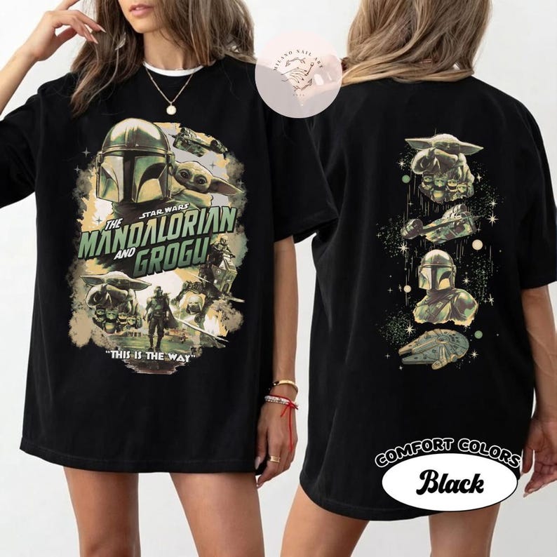 May include: Black t-shirt with a Star Wars design featuring The Mandalorian and Grogu. The front graphic includes the text "The Mandalorian and Grogu" and "This is the Way". The back graphic includes images of Grogu, the Mandalorian, and the Millennium Falcon.