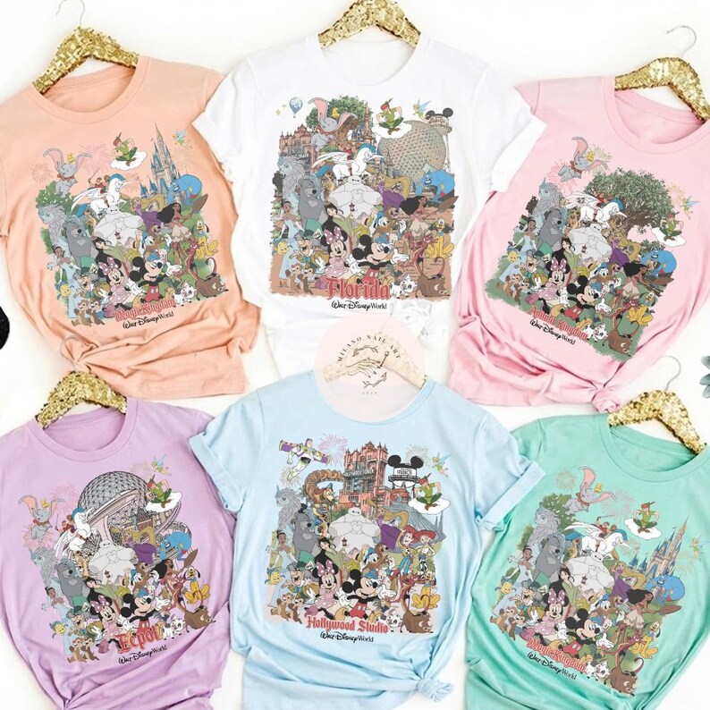 Puede incluir: Seis camisetas coloridas con gr&aacute;ficos de personajes de Disney. Las camisetas son melocot&oacute;n, blancas, rosas, lavanda, azul claro y verde menta. Cada camiseta presenta un gr&aacute;fico diferente del parque Disney, incluyendo el texto "Florida Walt Disney World" y "Hollywood Studio Walt Disney World".